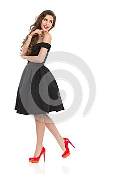 Elegant Woman In Black Cocktail Dress Is Looking Over Shoulder