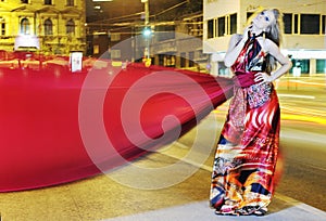 Elegant woman on city street at night