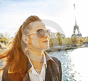 Elegant woman on embankment in Paris looking into the distance