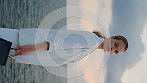 Elegant woman enjoy seascape in front cloudy sky vertically. Lady looking sunset