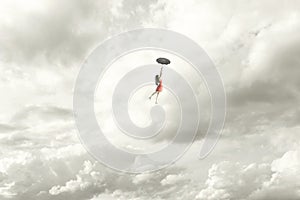 elegant woman flying in the middle of the clouds hanging on her umbrella