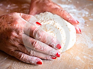 Elegant woman hands kneading and massaging homemade bread dough