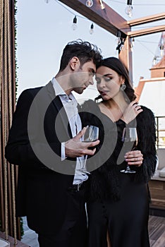 elegant woman and man holding glasses