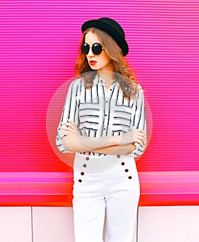 Elegant woman model wearing black hat sunglasses white pants