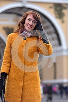 Elegant woman in the orange autumn coat