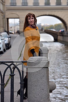 Elegant woman in the orange autumn coat