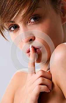 Elegant woman put her index finger to her lips photo