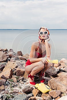 elegant woman in red bikini sunglasses and silk scarf posing