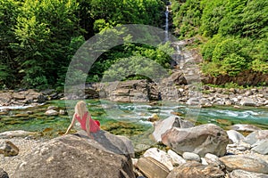 elegant woman by riverside of Verzasca river