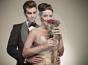 Elegant woman smelling a bunch of red roses