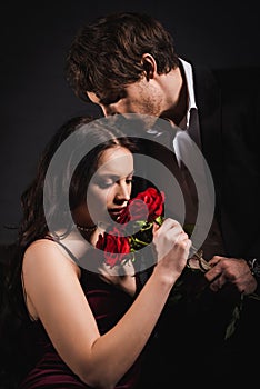 elegant woman smelling red roses near