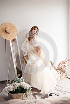 Elegant woman standing in front near the mirror and preparing for her wedding day