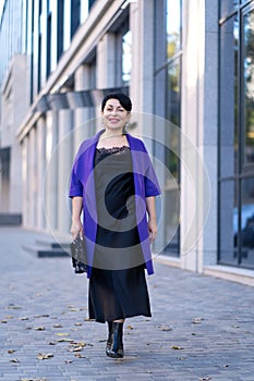 An elegant woman in a stylish outfit poses on a city street