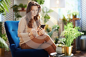 Elegant woman in sunny day sending text message using phone