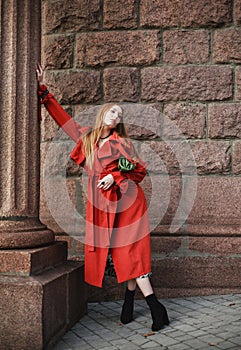 Elegant woman in terracotta coat on street of an old European city