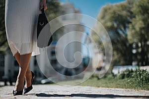 Elegant woman walking in the city - close-up on legs and high heels