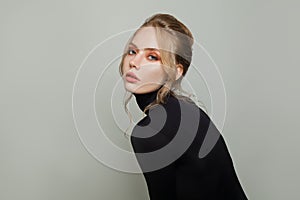 Elegant woman wearing black turtleneck sweater on white