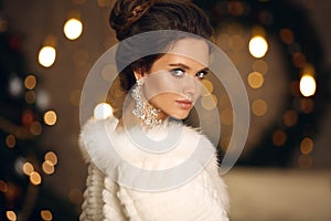 Elegant woman in white fur. Winter fashion portrait of Beautiful bride young with diamond earrings and necklace jewelry set.