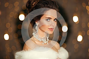 Elegant woman in white fur. Winter fashion portrait of Beautiful bride young with diamond earrings and necklace jewelry set.