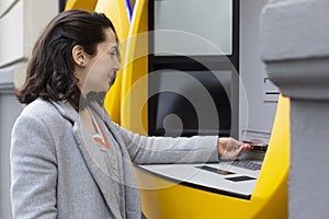 Elegant woman withdrawing cash at an ATM machine