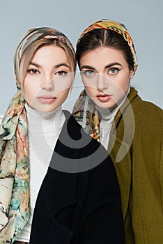elegant women in patterned kerchiefs looking