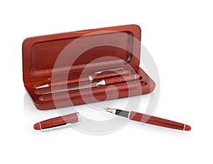 Elegant wooden ballpoint pen, fountain pen, letter opener in an opened wooden case isolated on white background.