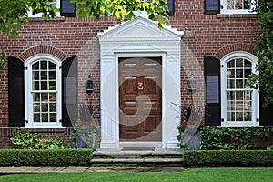 Elegant wooden front door of  traditional brick house