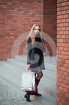 Elegant young beautiful women holding shopping bags, walking away from shop. Sale, consumerism and people concept