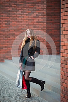 Elegant young beautiful women holding shopping bags, walking away from shop. Sale, consumerism and people concept