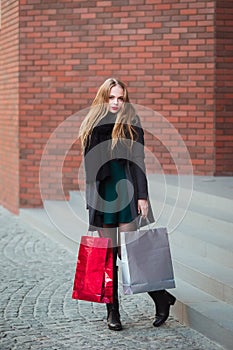 Elegant young beautiful women holding shopping bags, walking away from shop. Sale, consumerism and people concept