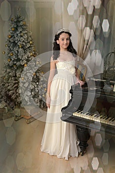 Elegant young brunette with oriental appearance in a white dress at the piano