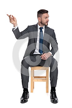 Elegant young businessman looking to side and gesticulating photo