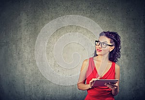 Elegant young businesswoman in red dress using tablet