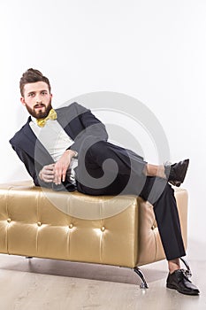 Elegant young handsome man in black classic suit with yellow bow-tie