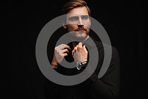 Elegant young handsome man in black suit. Studio fashion portrait