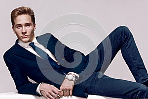 Elegant young handsome man with a wristwatch. Fashion portrait studio