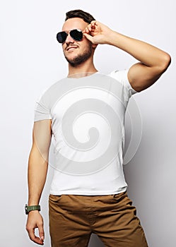 Elegant young handsome manin smart casual wear and sunglasses.