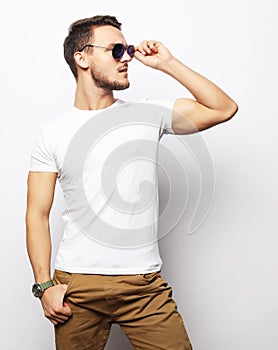 Elegant young handsome manin smart casual wear and sunglasses.