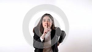 Elegant young lady making silencing gesture