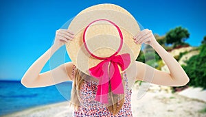 Elegant young lady in summer hat on beach vacation