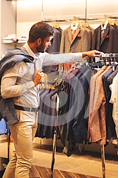 Elegant young man shopping in menswear photo