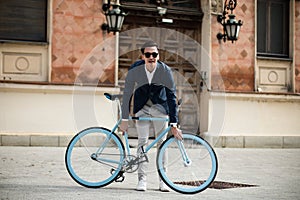 Elegant young man in suit with bicycle