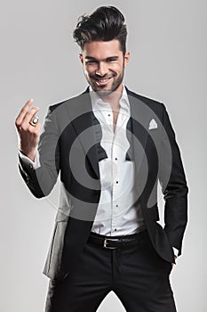 Elegant young man in tuxedo snapping his finger