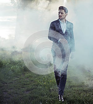 Elegant young man walking in the morning haze