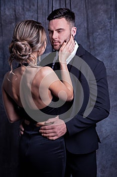 Elegant young man and woman tenderly embrace each other enjoying this moment