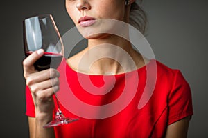 Elegant young woman having a glass of red wine