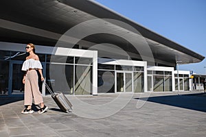 Elegant young woman with luggage at a train station. tourism concept