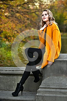 Elegant young woman posing in autumn park.