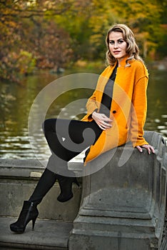 Elegant young woman posing in autumn park.