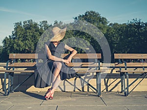 Elegant young woman sitting on park bench